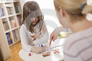 Mother and daughter playing ludo board game