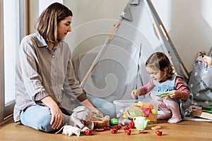 mother and daughter playing tea party at home