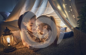 Mother and daughter playing in tent