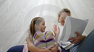 Mother and daughter playing in tent at home