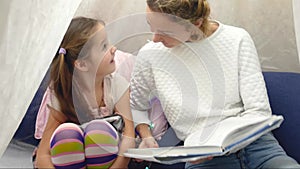 Mother and daughter playing in tent at home