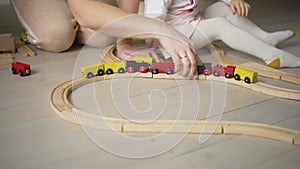 Mother and daughter playing together with toys indoor at home. Mom helps her baby girl. Family lifestyle concept