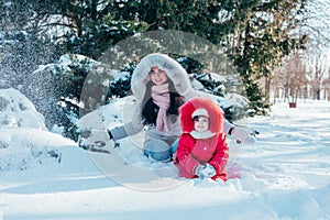 Mother and daughter playing on winter park