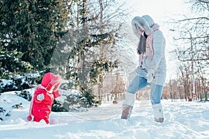 Mother and daughter playing on winter park