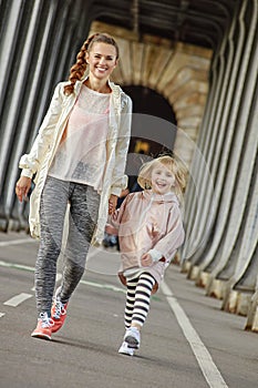 Mother and daughter on Pont de Bir-Hakeim bridge going forward