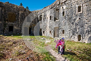 Mother and daughter posing in front of ruins of first world war fortress.