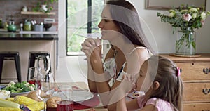 Mother and daughter praying before having meal at dining table 4k