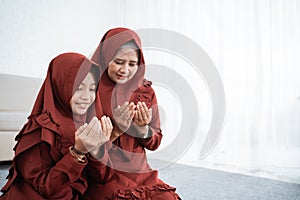 Mother and daughter praying together