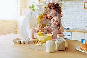 Mother and daughter prepare a cake together in the kitchen