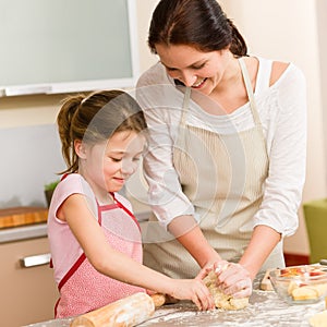 Mother and daughter prepare dough home cake photo