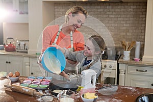 Mother and daughter preparing cup cake in kitchen