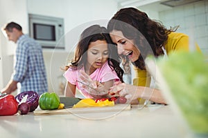 Mother and daughter preparing salad in kitchen