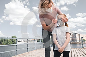 mother and daughter in protective masks on bridge air