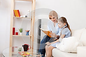 Mother and daughter reading book at home