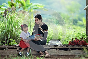 Mother and daughter are reading book together this is learning