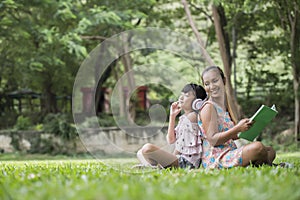 Mother and daughter reading a fairytale to her daughter listen sound with headphone