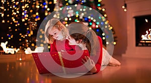 Mother and daughter reading at fire place on Christmas eve