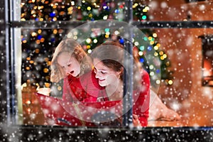 Mother and daughter reading at fire place on Christmas eve