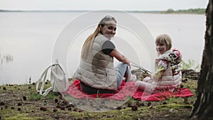 Mother and daughter are relaxing on the beach.