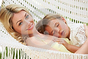 Mother And Daughter Relaxing In Beach Hammock