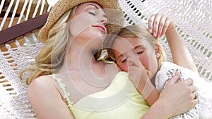 Mother And Daughter Relaxing In Beach Hammock