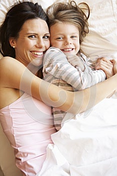 Mother And Daughter Relaxing In Bed