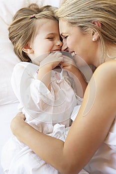 Mother And Daughter Relaxing In Bed