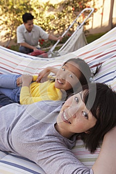 Mother And Daughter Relaxing On Hammock
