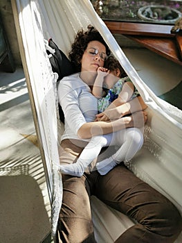 Mother and daughter relaxing in a hammock in the afternoon