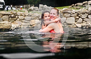 Mother and daughter relaxing in natural thermal water roman spa