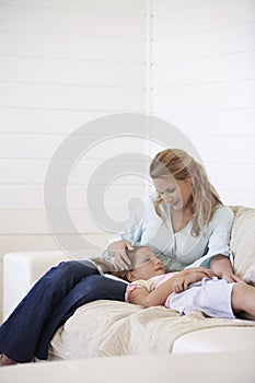 Mother And Daughter Relaxing On Sofa