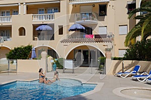 Mother and daughter resting in pool located in photo