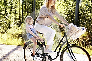 Mother and daughter riding bike in the woods