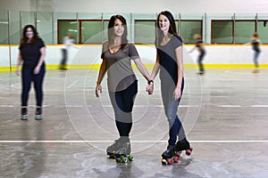 Mother and daughter at roller skating rink focus on mom