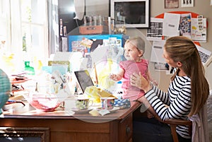 Mother With Daughter Running Small Business From Home Office