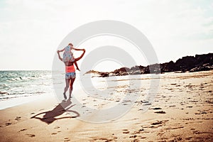 Mother and daughter running together along the seashore on the beach - Happy family piggyback at sunset