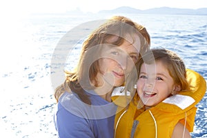 Mother and daughter safety vest backlight sea photo
