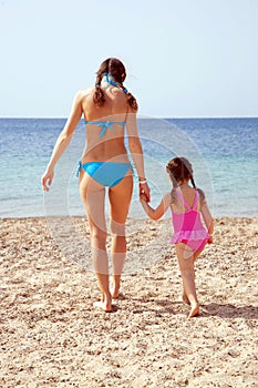 Mother and daughter on the sandy beach.