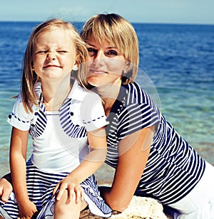 mother with daughter at sea cost together, happy real family smi