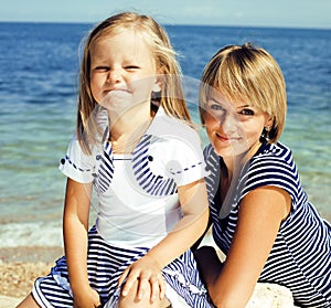 mother with daughter at sea cost together, happy real family smi