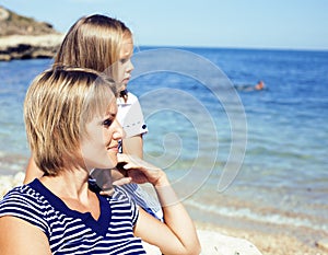 Mother with daughter at sea cost together, happy real family smiling looking to horizont, lifestyle people concept, on