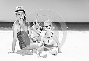 Mother and daughter on seashore with windmill toy