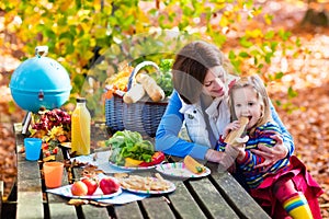 Mother and daughter set table for picnic in autumn