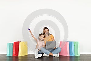 Mother And Daughter Shopping Online With Laptop And Credit Card At Home