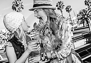 Mother and daughter showing tongues after drinking cocktail