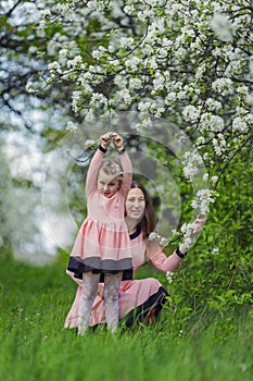 mother and daughter sitting in an apple orchard