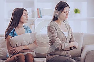 Mother and daughter sitting on couch after quarrel