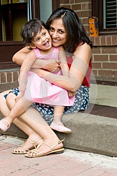 Mother and daughter sitting at the doorstep