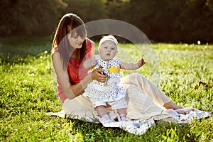 Mother and daughter sitting on the grass