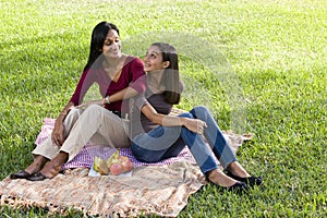 Mother and daughter sitting on picnic blanket